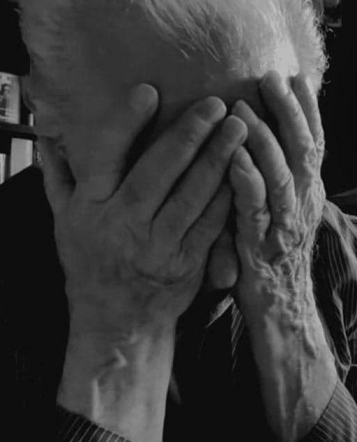 Old Man Covers Face in Despair
