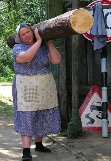 Babushka Carries Log Without Breaking a Sweat